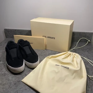 Axel Arigato clean 360 laceless - Säljer dessa svartvita Axel Arigato skor i Mocka! Skorna är i bra skick och inte använda allt för mycket. Skorna har inga större defekter än lite slitningar på mockan och lite nött på sulan. De är lite stora i storleken så de passar även dig som har storlek 40. Nypris ligger på 2600kr! Hör gärna av dig vid intresse! Kom ihåg priset är inte hugget i sten! 😀