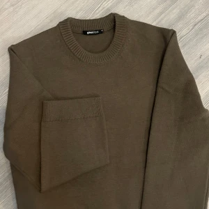 Brun stickad tröja från Gina Tricot - Säljer en mysig brun stickad tröja från Gina Tricot i storlek XS. Perfekt för höst och vinter med sin varma och bekväma passform. Tröjan har långa ärmar och en ribbad rund halsringning. Den är i mycket bra skick och redo för nya äventyr!