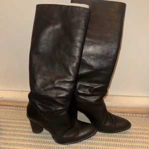 Svarta stövlar med klack - Säljer ett par snygga svarta stövlar i skinn med klack. De har en elegant spetsig tå och är perfekta för höst och vinter. Stövlarna är i rätt bra skick och passar både till vardags och fest. Orginalpris: 1 295kr.