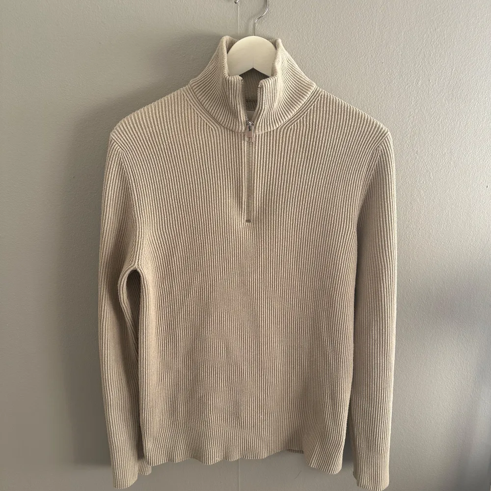 Säljer en snygg beige ribbad tröja från Jack & Jones. Den har en dragkedja vid halsen och är perfekt för kyliga dagar. Tröjan är i mycket bra skick och passar både till vardags och lite finare tillfällen. Perfekt för höst och vinter! Nypris 599! Mitt pris 299, i väldigt bra skick.. Tröjor & Koftor.