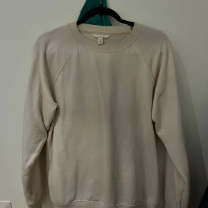 Beige tröja från H&M - Säljer en enkel och stilren beige tröja från H&M i storlek XS. Perfekt för en avslappnad look, med långa ärmar och rund hals. Tröjan är i bra skick och passar perfekt till både jeans och kjol. Ett måste i garderoben för alla säsonger!