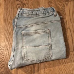 Ljusblå jeansbyxor med snörning - Säljer ett par ljusblå jeansbyxor i bra skick. De har en avslappnad stil med snörning i midjan och praktiska fickor både fram och bak. Perfekta för en casual look och passar till de flesta tillfällen. Sköna och lätta att matcha med olika outfits! Brand= Jack Jogger