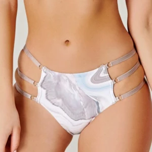 Mönstrad trosa med remmar - Snygg bikiniunderdel/trosa med abstrakt mönster i beige och bruna toner. Den har flera remmar på sidorna som ger en unik look. Säljer matchande överdel. Garderobsrensning så kika gärna på övriga auktioner.