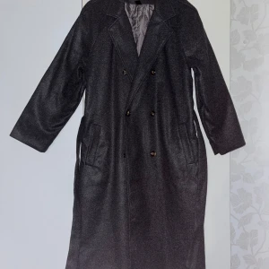 Grå kappa från Shein - Snygg grå kappa från Shein med dubbelknäppning och bälte i midjan. Den har långa ärmar och en quiltad insida för extra värme. Perfekt för kyliga dagar. Den är bara testad och helt ny. 