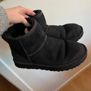 Svarta boots från UGG - Säljer ett par svarta UGGs i modellen classic mini. boots i mocka med mjukt foder som är väldigt varma på vintern. Bootsen är i bra skick utan skador! Skulle säga att de passar str 40/41