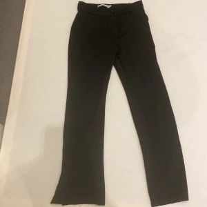 Svarta byxor från 157 - Säljer ett par svarta byxor från 157 i storlek 140. Byxorna har en rak passform och är tillverkade i ett mjukt material. Perfekta för en stilren look.