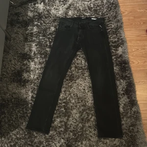 Svarta jeans från Replay - Snygga svarta jeans från Replay, modell Rocco med comfort fit. Perfekta för en stilren look. De har en klassisk design med fem fickor och knappgylf.