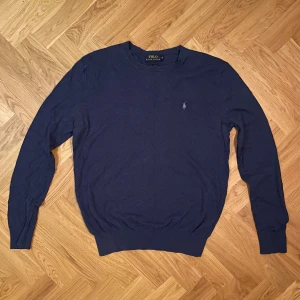 Mörkblå Kashmir Bomull tröja från Polo Ralph Lauren - Säljer en stilren klassisk mörkblå tröja från Polo Ralph Lauren. Tröjan är tillverkad i en mjuk blandning av bomull och kashmir, vilket ger en lyxig känsla. Skriv vid frågor! Fraktar samma dag köpet genomförs. Mycket bra skick. 
