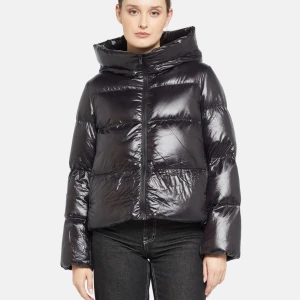 Svart glansig pufferjacka - Snygg svart glansig pufferjacka med dragkedja och huva. Perfekt för vintern😊original pris ligger på 1800kr. Helt oanvänd med prislapp, ligger kvar i låda 