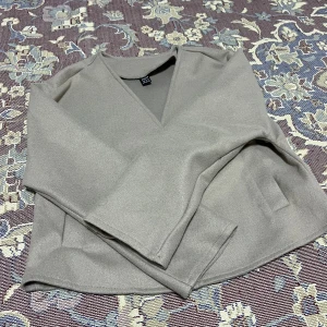 Beige kavaj med knappar - Snygg beige kavaj med v-ringning och två stora knappar framtill. Den har en croppad passform och långa ärmar. Jätte skön att ha på sig. Har använt den 1 gång säljer den för att jag köpt fel storlek