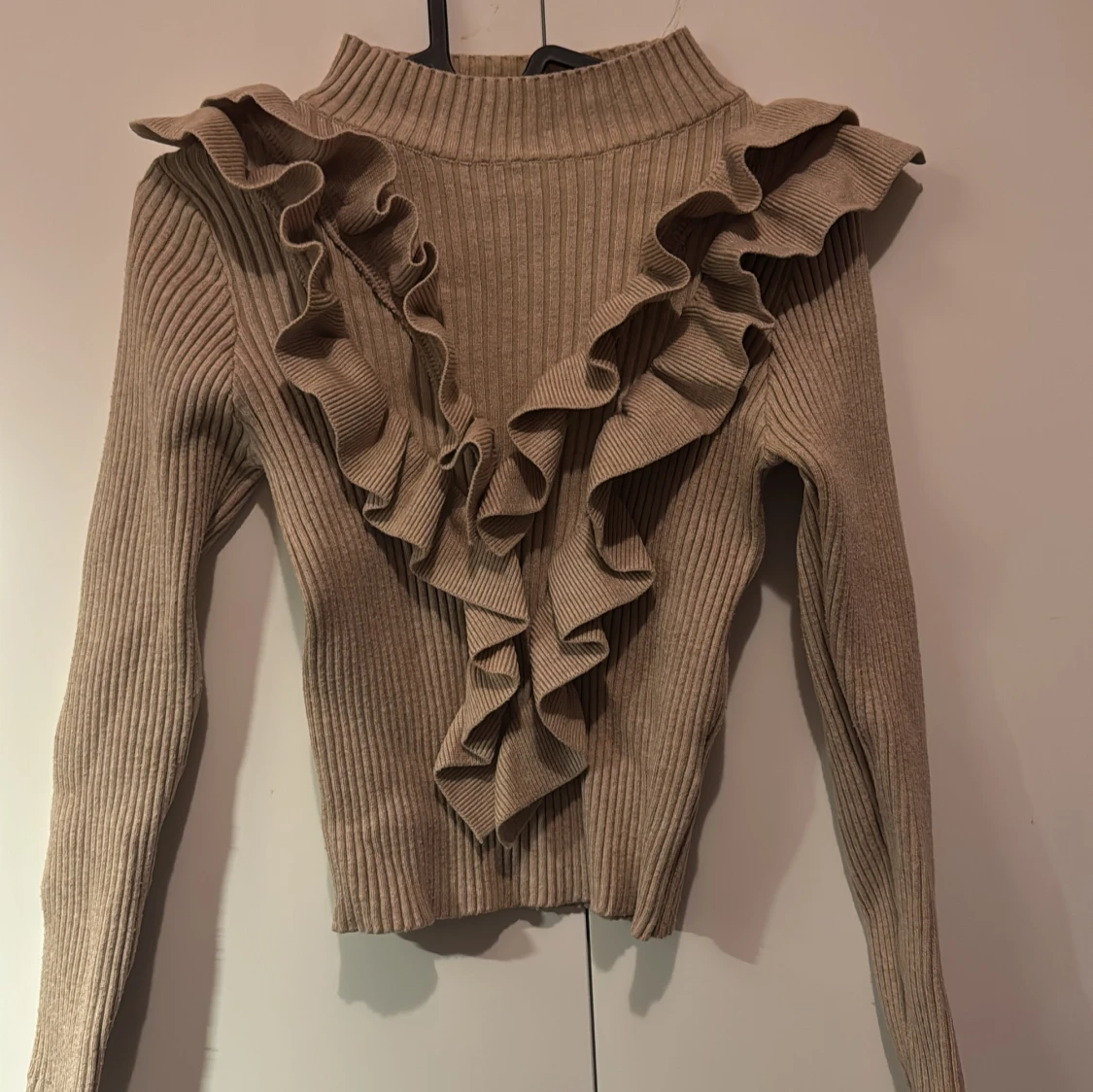 Beige ribbad tröja med volangdetaljer