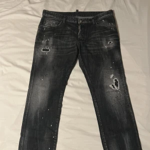 (ÄKTA) Svarta Dsquared2 jeans - Snygga (äkta) svarta jeans från Dsquared2 med slitna detaljer och en cool, distressed look. Perfekta för en avslappnad stil. De har en klassisk femficksdesign och knappgylf. Helt nya har inte använt så mycket då de är små. Säljer inte för mindre än 3000! Nypris 6,200 mitt pris 3,000