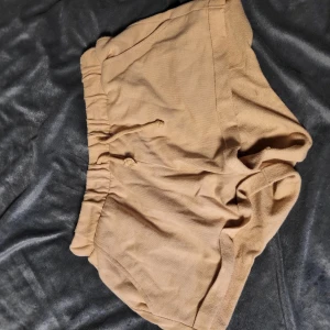 Beige shorts från Divided - Säljer ett par bekväma beige shorts från Divided. De har en elastisk midja för extra komfort och en avslappnad passform. Perfekta för varma sommardagar!