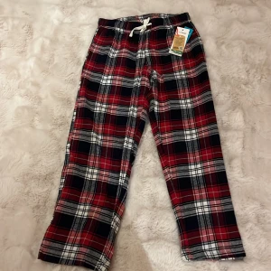 Röd- och svart-rutiga byxor från Mywear - Säljer ett par mysiga röd- och svart-rutiga byxor från Mywear. Byxorna har en bekväm dragsko i midjan och är perfekta för en avslappnad stil. De är tillverkade i ett mjukt material som passar bra för kalla dagar. Helt nya aldrig testade😘😘Tar emot prisförslag😚