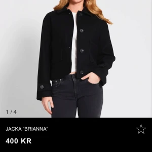 Svart jacka 'Brianna' - Snygg svart jacka 'Brianna' med knappar framtill och långa ärmar. Perfekt för en stilren look. Jackan har en klassisk design med en rak passform.