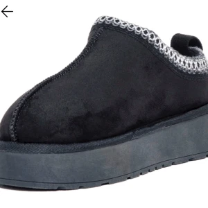 Svarta slip-on skor med platåsula - Stilrena svarta slip-on skor med en bekväm platåsula. Skorna har en dekorativ stickad kant i grått och är tillverkade i ett mjukt material som ger en skön passform. Använt som utomhus skor.