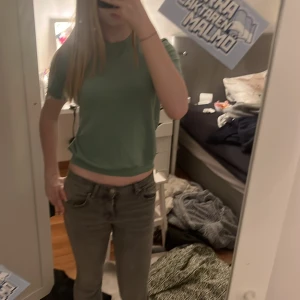 Grön stickad t-shirt från Vero Moda - Säljer en stilren grön t-shirt från Veromoda i storlek XS. T-shirten har en klassisk design med korta ärmar och rund halsringning. Perfekt för en avslappnad look.