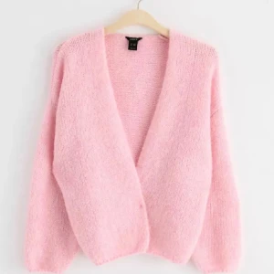 Rosa fluffig kofta från Lindex  - Mysig rosa kofta från Lindex i ett fluffigt material. Perfekt för kyliga dagar med sin avslappnade passform och långa ärmar. Enkelt att matcha med olika outfits för en söt och bekväm look.