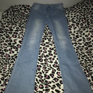 Ljusblå bootcut jeans - Säljer ett par ljusblå bootcut jeans i bra skick. De har en snygg tvätt med lite slitningar framtill och bakfickor med diskreta detaljer. Perfekta för en avslappnad vardagslook eller en utekväll. Passar till det mesta och är superbekväma!