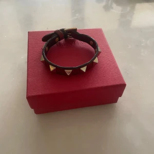  Vinrött valentino armband  - Säljer ett vinrött Valentino armband. Som man kan se på bilderna är de andvänt men har fortfarande mycket kvar att ge. Kontakta gärna vid frågor!