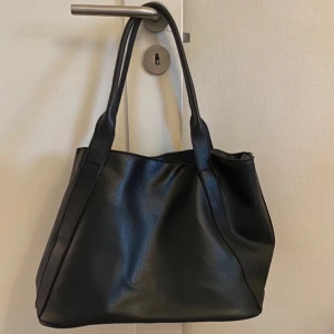 Svart väska - En väska som jag köpte på Vinted men som inte kommit till användning då den inte var storleken jag hade tänkt. Inga defekter vad jag vet. Väskan är 25cm hög och 35 cm bred, skriv om du har frågor!!🩷