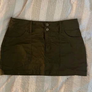 Mini kjol - Minikjol i khaki färg, helt oanvänd från NAKD. NYPRIS 399kr. Säljer för 100kr. Köp via ”köp nu”🩷