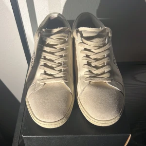 Beige sneakers från Saint Laurent - Säljer ett par Saint Laurent Courtside Classics. Perfekta för både vardags och finare tillställningar! Skorna är i väldigt bra skick då de bara är använda 2-3 gånger. Box, Dustbags och extrapar skosnören medkommer. (Hör gärna av er om ni har frågor).