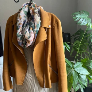 Brun mockajacka med dragkedja - Säljer en snygg brun mockajacka med dragkedja och coola detaljer som knappar vid kragen. Jackan har en stilren design och passar perfekt för höst och vår. Den är långärmad och har en normal passform. Perfekt för att ge din outfit en extra touch!