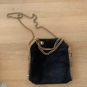 Stella McCartney Falabella tote bag mini - Jätte fin väska från Stella McCartney. Falabella tote bag mini i svart och gulddetaljer. I bra använt skick. Nypris ca 10 000kr