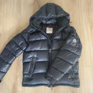 Moncler maya jacka - Säljer en Moncler maya jacka som är i ett bra skick! Storlek 3 som motsvarar M! Jackan är i en marinblå färg! Har små defekter! Hör gärna av dig om du har frågor!