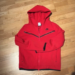 Röd huvtröja från Nike - Säljer en snygg röd huvtröja från Nike med dragkedja och huva. 