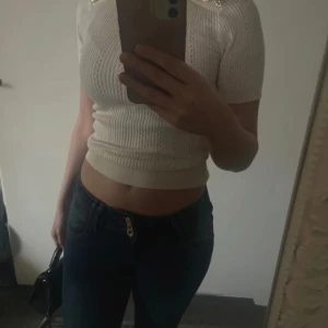 Topp - Vit snygg polotopp med guld knappar. Perfekt för en chic och elegant look. Passar till allt✨