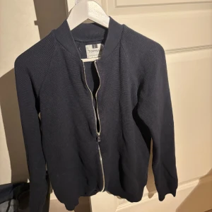 Full-zip mörklblå TOPMAN - Säljer en stilren mörkblå kofta från Topman. Den är i utmärkt skick, säljer för att den inte passar. Hör av dig vid minsta lilla fråga🙌