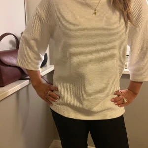 Vit ribbad topp - Säljer en stilren vit ribbad topp med trekvartsärm. Perfekt för en chic och avslappnad look. Passar bra till både jeans och kjol. Hör av dig vid intresse! 🤍