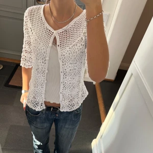 Vit stickad kofta  - Trekvartsärmad kofta med mönster från Isolde i storlek M, skulle säga att den även passar S. Fint skick. Använd gärna köp nu!