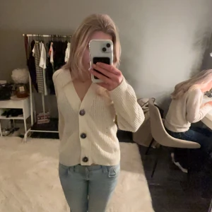 Vit kofta med knappar - Säljer en mysig vit kofta med stora knappar framtill. Perfekt för kyliga dagar och lätt att matcha med olika outfits. Koftan har en klassisk design med långa ärmar och en bekväm passform.💕💕