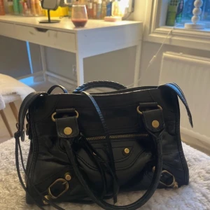 Svart handväska med dragkedja - !!!!PRIS GÅR ATT DISKUTERAS VID SNABB AFFÄR!!!!                           Snygg svart handväska i skinn med dragkedja och guldfärgade detaljer. Köpte väskan för 600 på vinted säljer nu endast för jah behöver pengar! Den ser mer vintage ut i verklighet än på bild. 