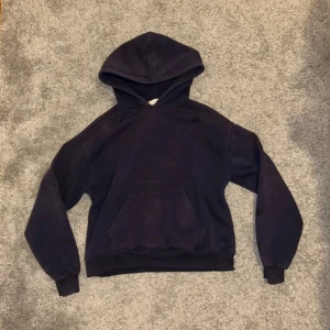 Svart hoodie från Gina Tricot - Säljer en klassisk svart hoodie från Gina Tricot. Den har en bekväm passform med en stor ficka framtill och en mysig huva. Perfekt för en avslappnad stil.