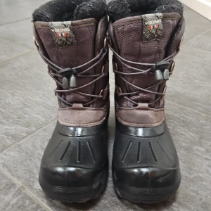 Vinterstövlar/Regnstövlar från Viking - Säljer ett par robusta vinterstövlar från Viking. De är svarta med bruna detaljer och har en varm fodring. Stövlarna har snörning framtill och är perfekta för kalla vinterdagar.
