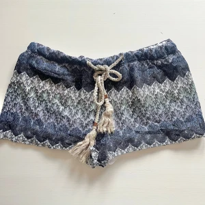 Mönstrade shorts med knytband - Snygga shorts med ett unikt mönster i blått, svart och vitt. De har ett dekorativt knytband i midjan som ger en avslappnad look. Perfekta för sommarens äventyr! Något nopprig på insidan men inget som stör 🙏