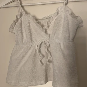 Vit topp med volangdetaljer - Säljs då den inte kommer till användning 