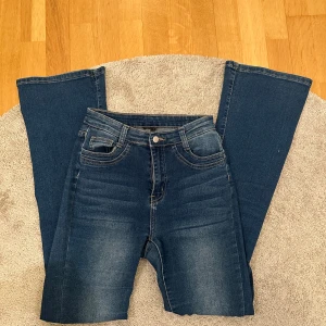 Blå jeans med bootcut - Snygga blå jeans med bootcut-stil och klassisk femficksdesign. De har en knapp och dragkedja framtill. Perfekta för en avslappnad look.