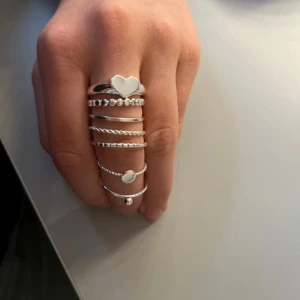 Set med silverringar - Ett set med flera stilrena silverringar i olika designer. Setet inkluderar ringar med hjärtan och pärlor, samt släta och tvinnade varianter. Perfekt för att mixa och matcha för en personlig stil💞