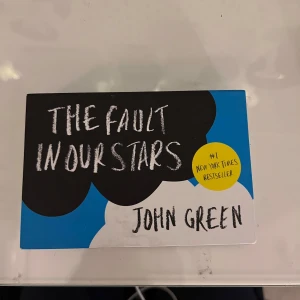 The Fault in Our Stars - Säljer boken 'The Fault in Our Stars' av John Green. En gripande berättelse om Hazel Grace Lancaster och Augustus Waters, två tonåringar som möts i en stödgrupp för cancerdrabbade. Boken utforskar kärlek, liv och död med humor och insikt. Perfekt för dig som gillar romantik och drama. - köpt för 142 kr 