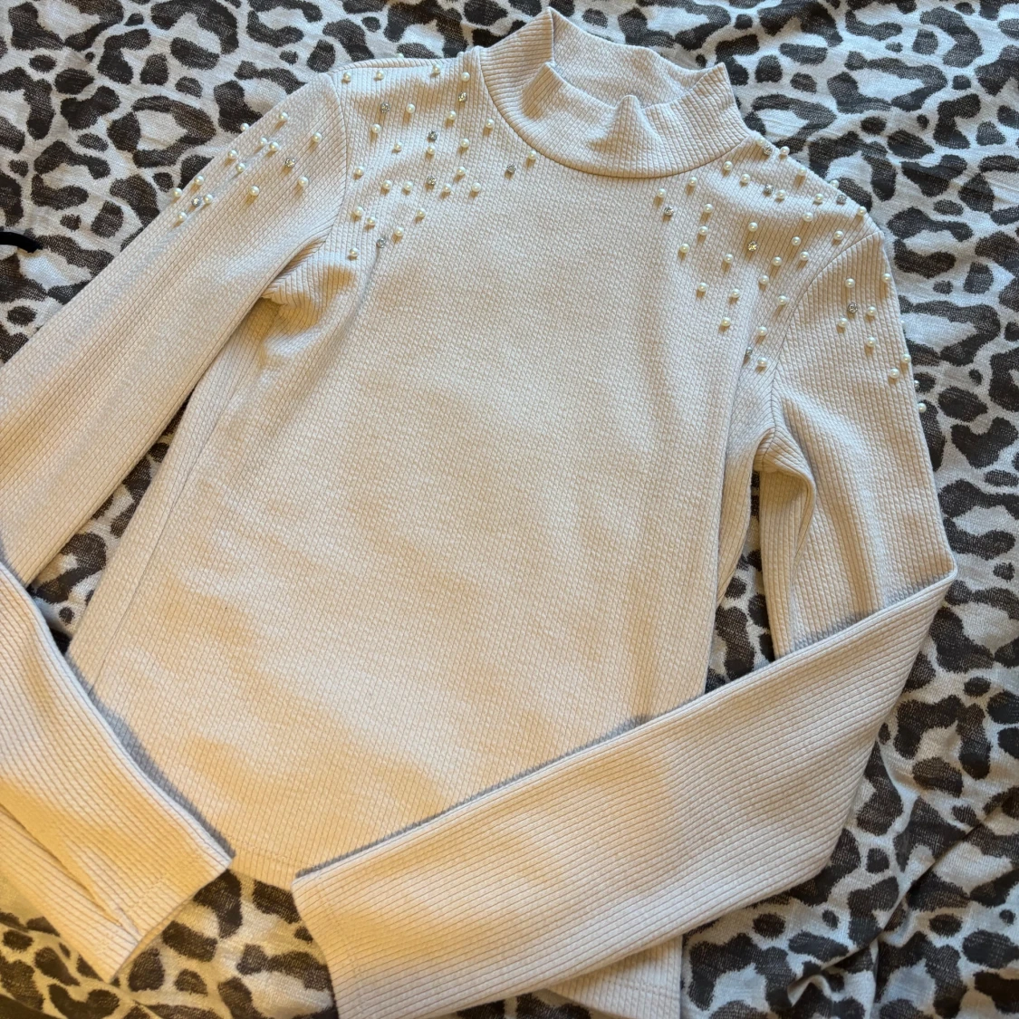 Beige ribbad polotröja med pärlor