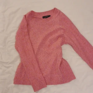Rosa stickad tröja från Vera moda - Mysig rosa stickad tröja från Ver moda med rund hals och långa ärmar. Perfekt för kyligare dagar och ger en härlig färgklick till garderoben. Tröjan har ribbade muddar vid ärmslut och nederkant.