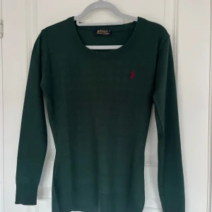Grön långärmad tröja från Polo Ralph Lauren - Snygg grön långärmad tröja från Polo Ralph Lauren med en liten röd logga på bröstet. Storlek xl i barnstolek så passé xs-s