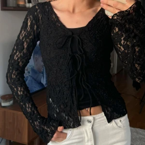 Svart spetstopp  - Svart spetstopp med knytning på bröstet, aldrig använd, från Gina tricot. Storlek xs