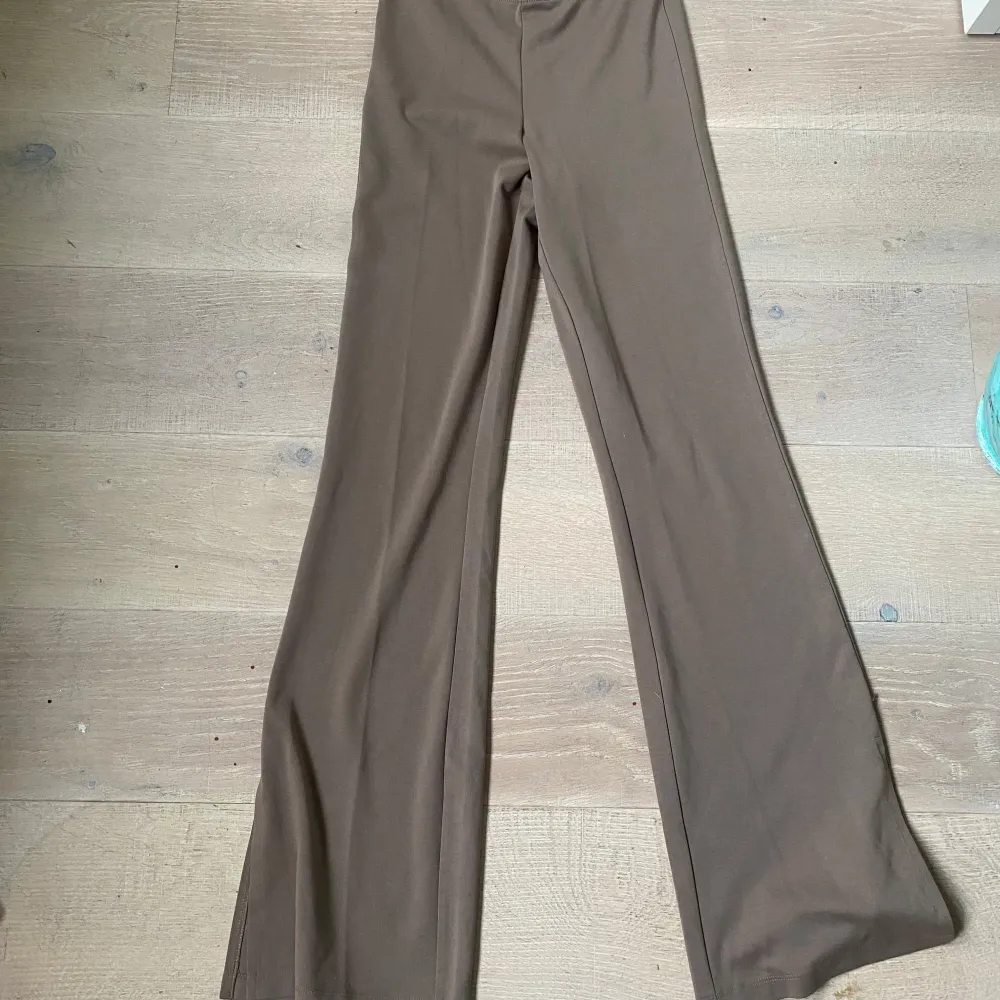 Snygga bruna byxor från 157 i storlek XS. De har en hög midja och en bootcut-stil som ger en trendig look. Perfekta för att matcha med en stickad tröja eller en blus.. Farkut & Housut.