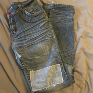 Grå jeans med patchar - Grå jeans med patchar på benen. 